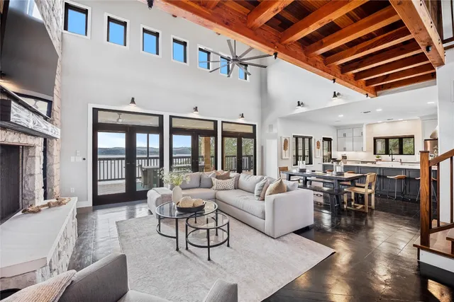 a living room with furniture kitchen view and a wooden floor