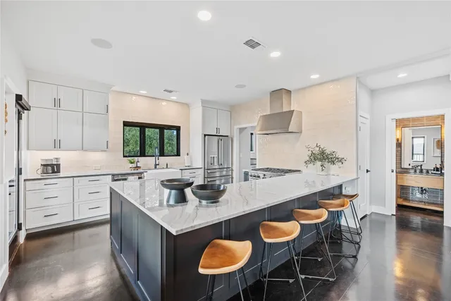a large kitchen with stainless steel appliances granite countertop a stove and a sink
