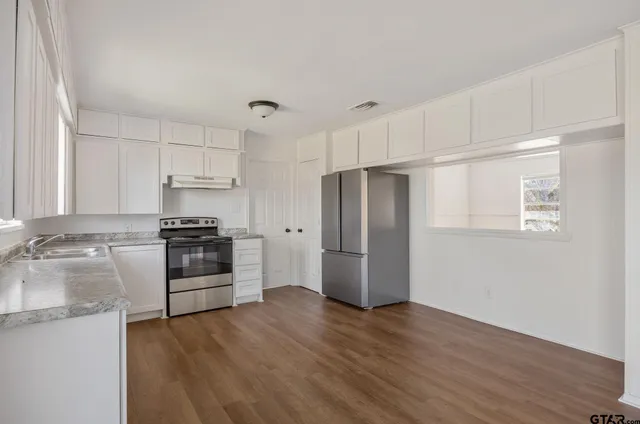 a view of a kitchen with wooden floor and electronic appliances
