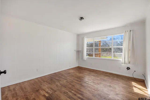 a view of empty room with wooden floor