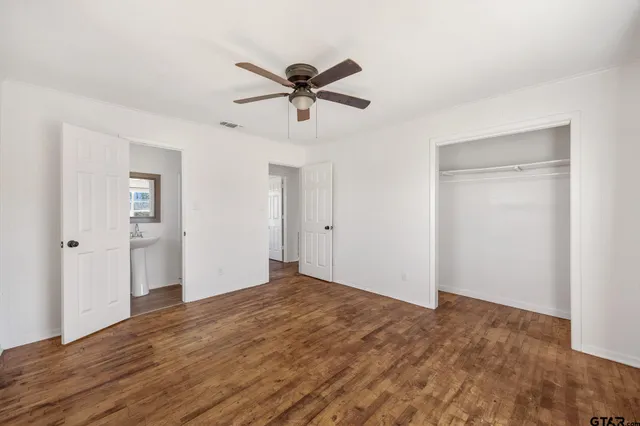 a view of a big room with wooden floor closet and ceiling fan