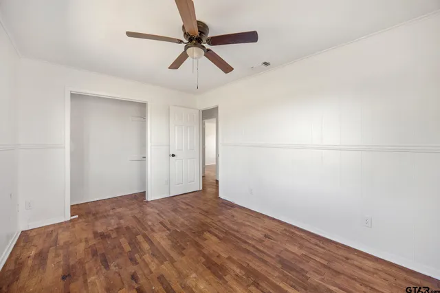 a view of an empty room with wooden floor