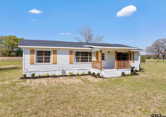 a view of a house with a yard and sitting area