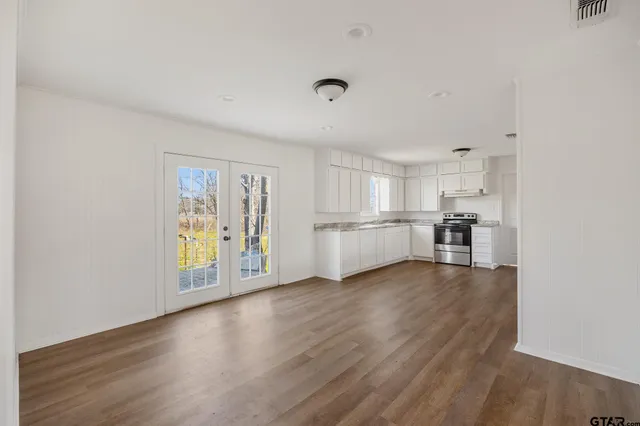 a view of a kitchen with wooden floor and a refrigerator