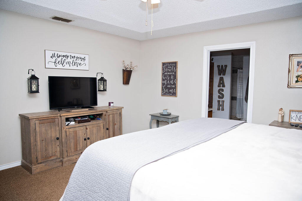 2917 Quail Ridge Road Denver City, TX 79323 - Photo 15 of 55 a bedroom with a bed and a flat screen tv