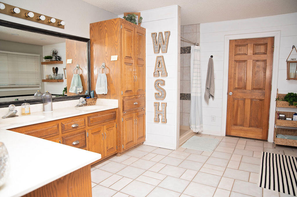 2917 Quail Ridge Road Denver City, TX 79323 - Photo 18 of 55 a bathroom with a sink a mirror and a shower