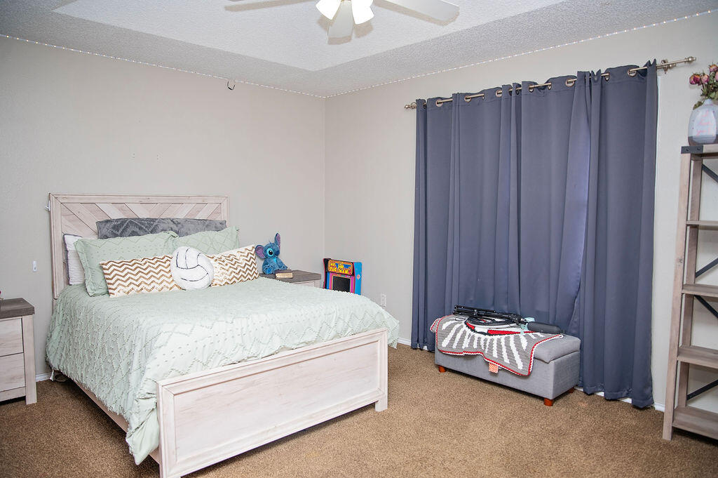 2917 Quail Ridge Road Denver City, TX 79323 - Photo 30 of 55 a bedroom with a bed and a chandelier