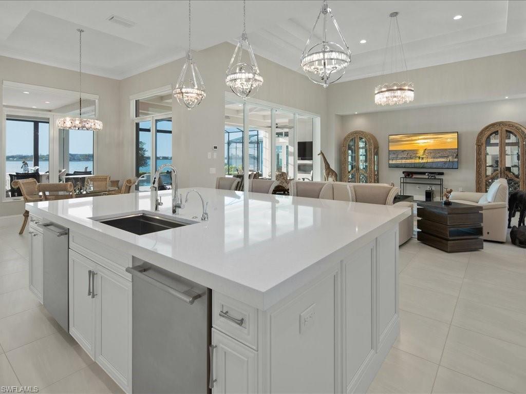 18460 Blue Eye Loop Fort Myers, FL 33913 - Photo 7 of 50 a kitchen with stainless steel appliances a kitchen island a stove a sink a dining table and chairs