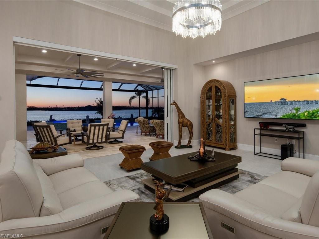 18460 Blue Eye Loop Fort Myers, FL 33913 - Photo 10 of 50 a living room with furniture a chandelier and a floor to ceiling window