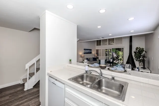 a kitchen with granite countertop a sink stove and cabinets