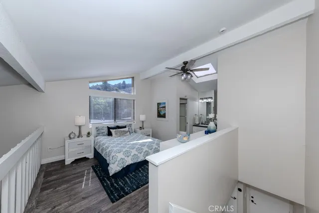 a bedroom with a bed and a lamp on dresser