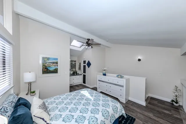 a bedroom with a bed wooden floor and window