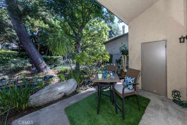 a view of a porch with chairs and potted plants