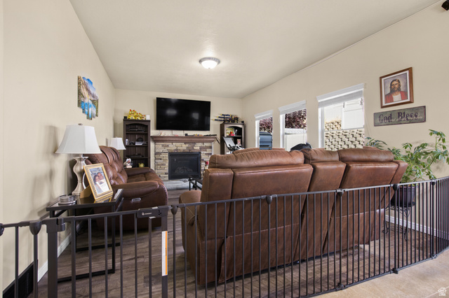 2005 Redtail Way Layton, UT 84040 - Photo 11 of 37 Living area featuring wood-finish flooring, a stone-faced fireplace, and a vaulted ceiling