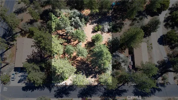 an aerial view of residential house with outdoor space and trees all around