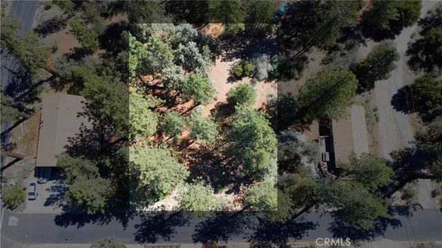 an aerial view of residential house with outdoor space and trees all around