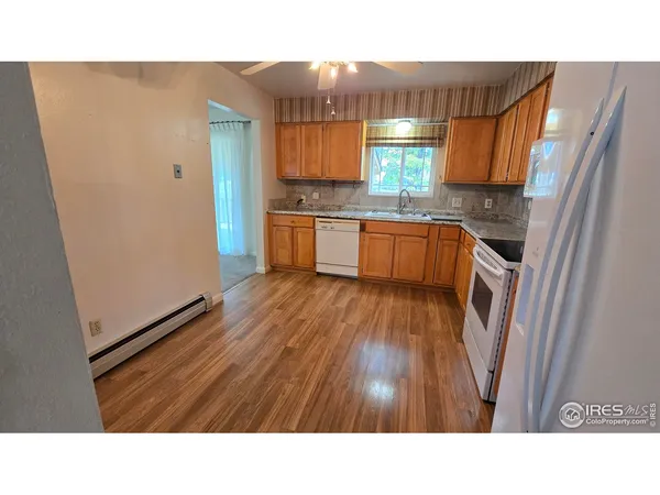 a kitchen with stainless steel appliances kitchen island granite countertop a sink refrigerator and cabinets