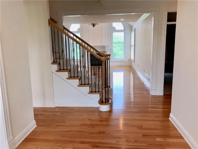 a view of entryway and hall with wooden floor