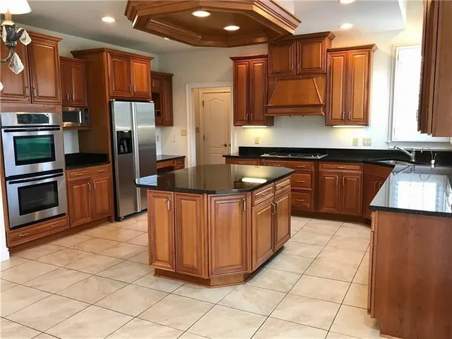 a kitchen with stainless steel appliances granite countertop a stove a sink dishwasher and a refrigerator