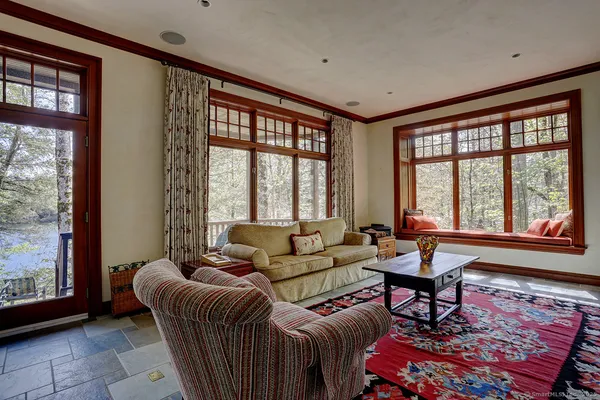 a living room with furniture large windows and a fireplace