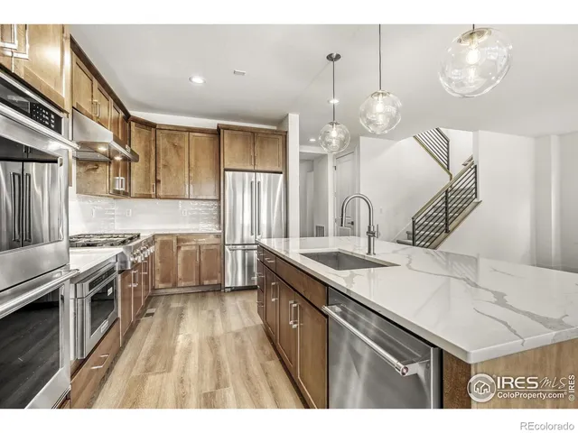 a kitchen with granite countertop a sink stainless steel appliances and cabinets