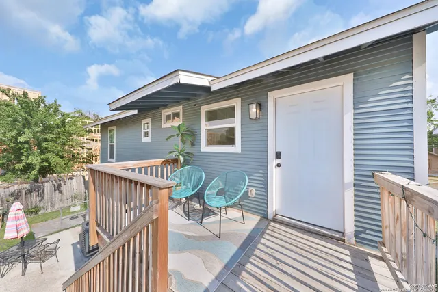 a view of a house with wooden deck and furniture