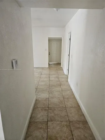 a view of a hallway with wooden floor and a white door