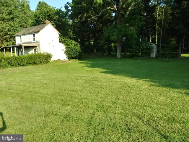 a view of a big yard with a house in the background