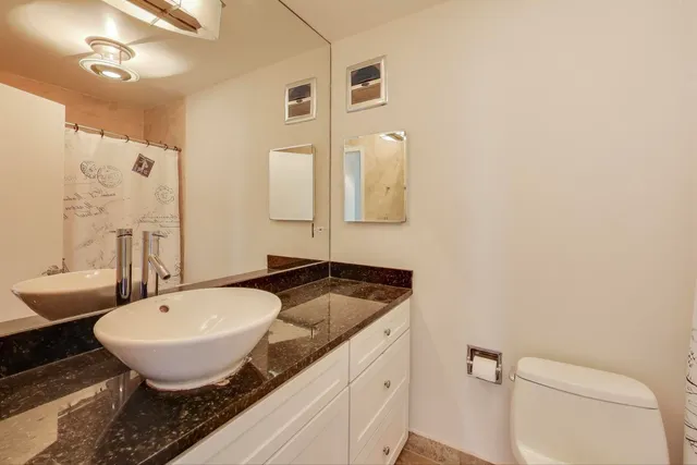 a bathroom with a granite countertop sink and a mirror