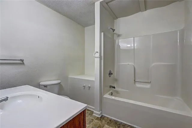 a bathroom with a tub shower sink vanity and a sink