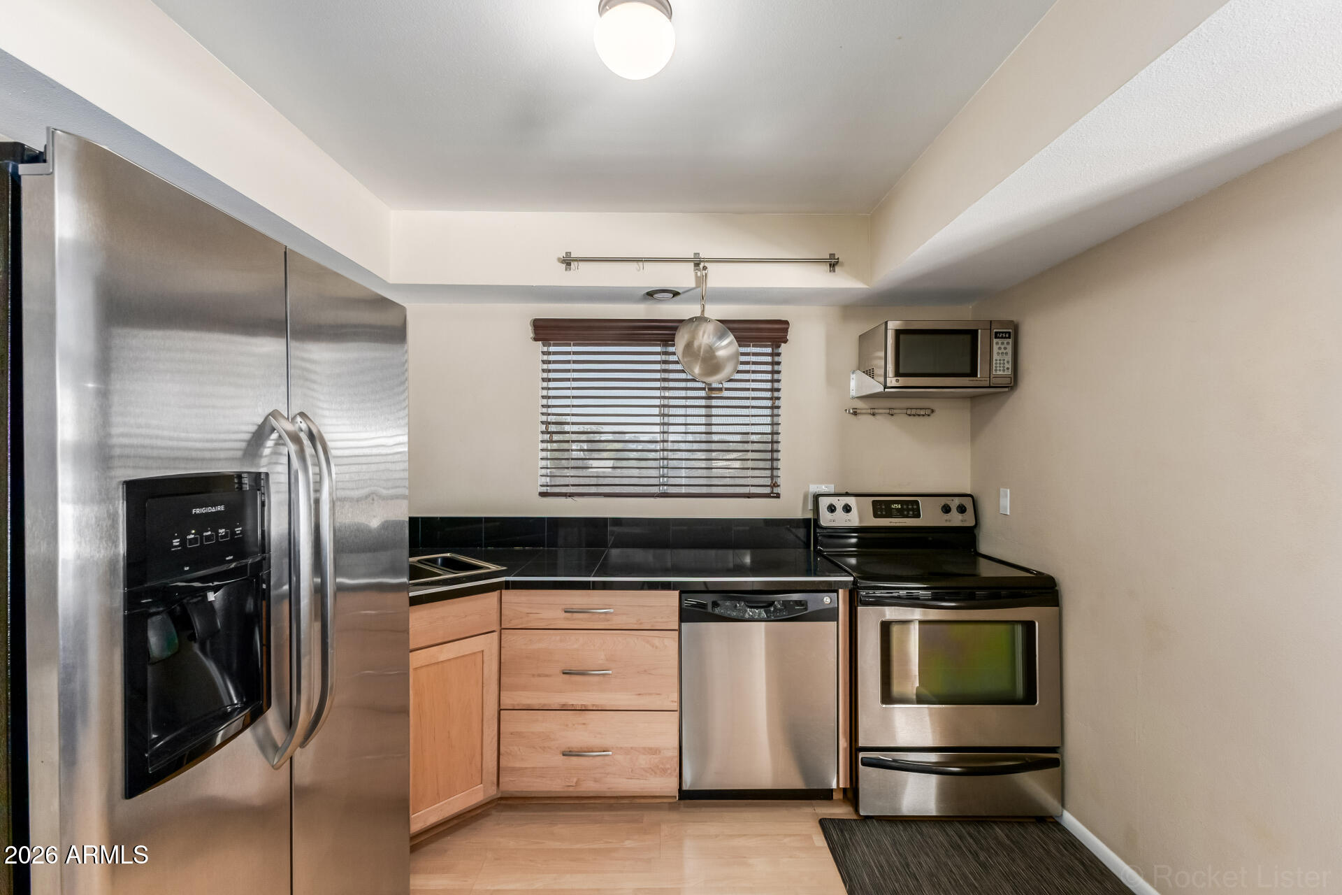 725 South Power Road, Unit 217 Mesa, AZ 85206 - Photo 12 of 29 a kitchen with granite countertop a stove and a refrigerator