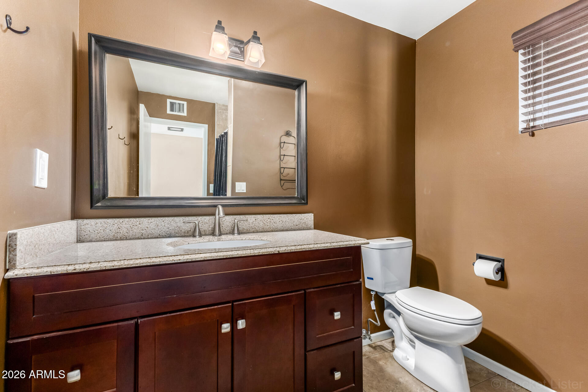 725 South Power Road, Unit 217 Mesa, AZ 85206 - Photo 19 of 29 a bathroom with a sink a toilet a mirror and vanity