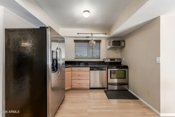 a kitchen with granite countertop a refrigerator and a sink