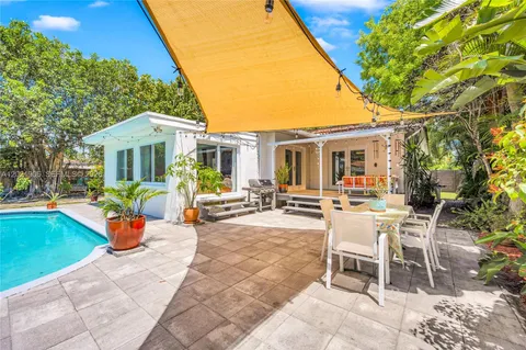 a view of a patio with a table and chairs under an umbrella
