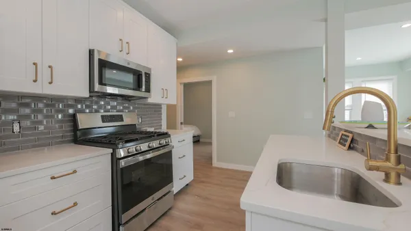 a kitchen with white cabinets and stainless steel appliances