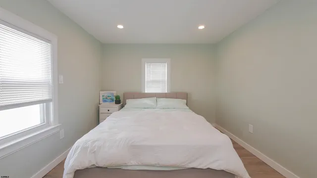 a bedroom with a bed and windows