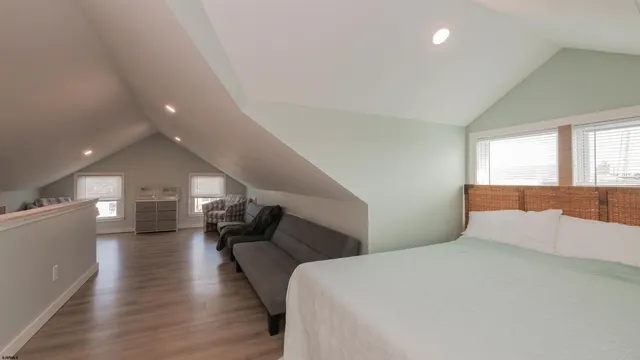 a bedroom with a large bed and wooden floor