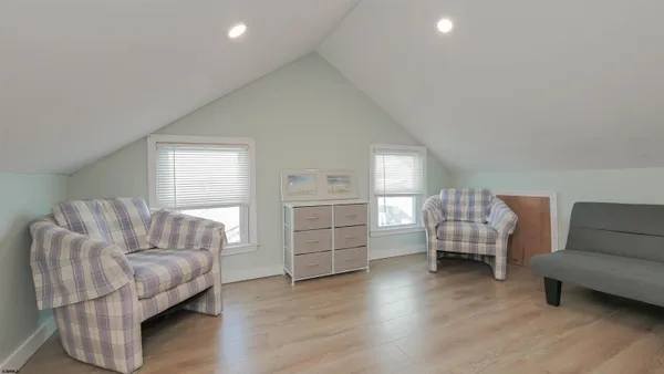 a bedroom with a large bed and wooden floor