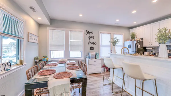 a very nice looking dining room with kitchen island furniture a large window and a refrigerator