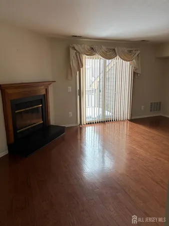 a view of wooden floor fire place and windows in a room