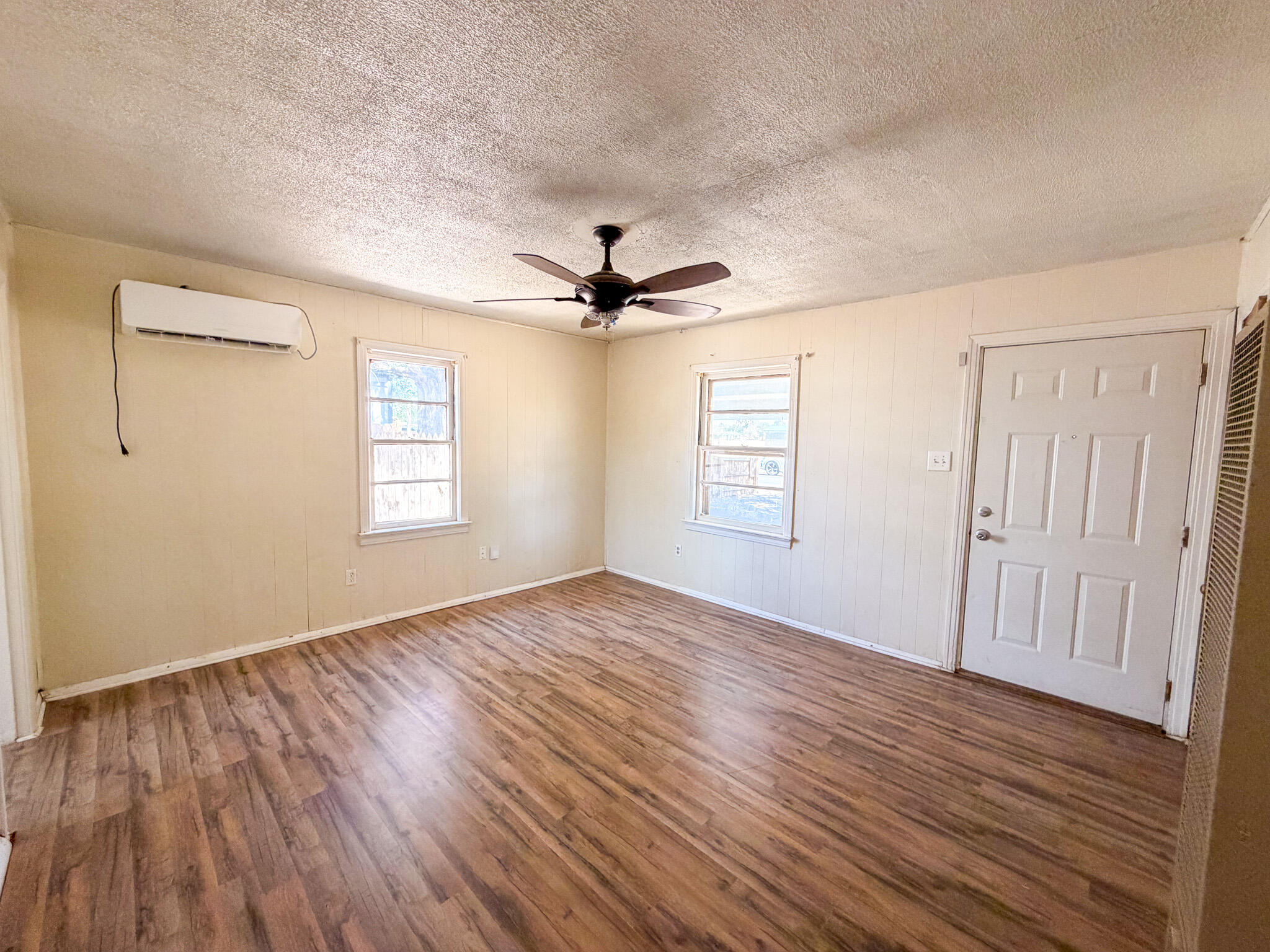 3207 Amherst Street Lubbock, TX 79415 - Photo 3 of 16 an empty room with wooden floor fan and windows