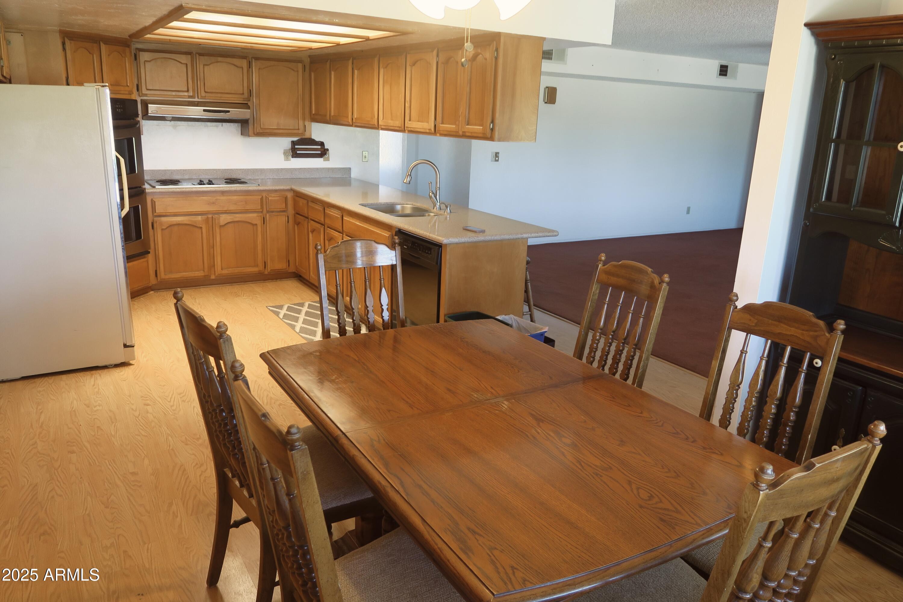 9208 South Palo Verde Road Buckeye, AZ 85326 - Photo 15 of 27 a kitchen with a table chairs and a refrigerator