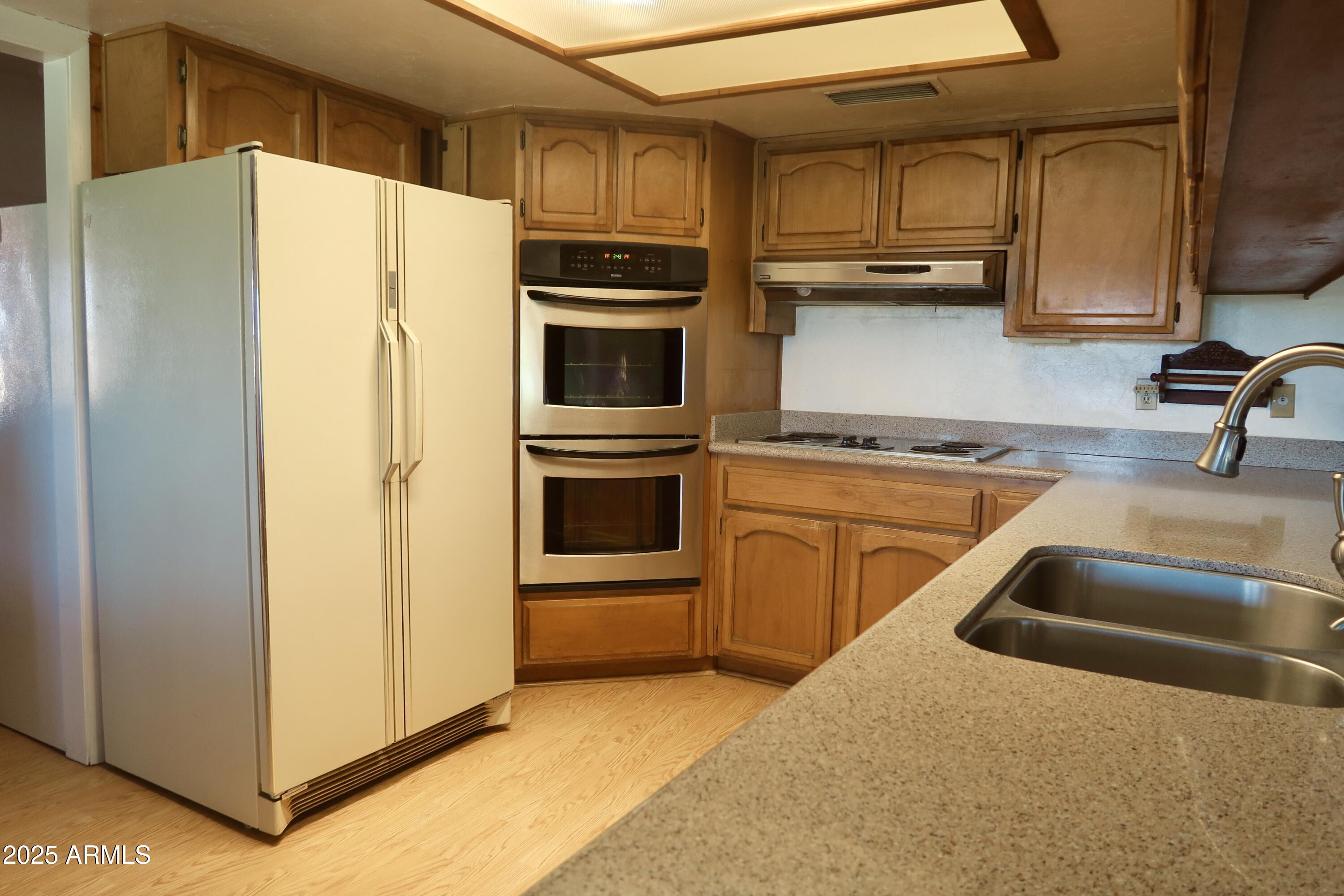 9208 South Palo Verde Road Buckeye, AZ 85326 - Photo 16 of 27 a kitchen with stainless steel appliances granite countertop a refrigerator and a sink