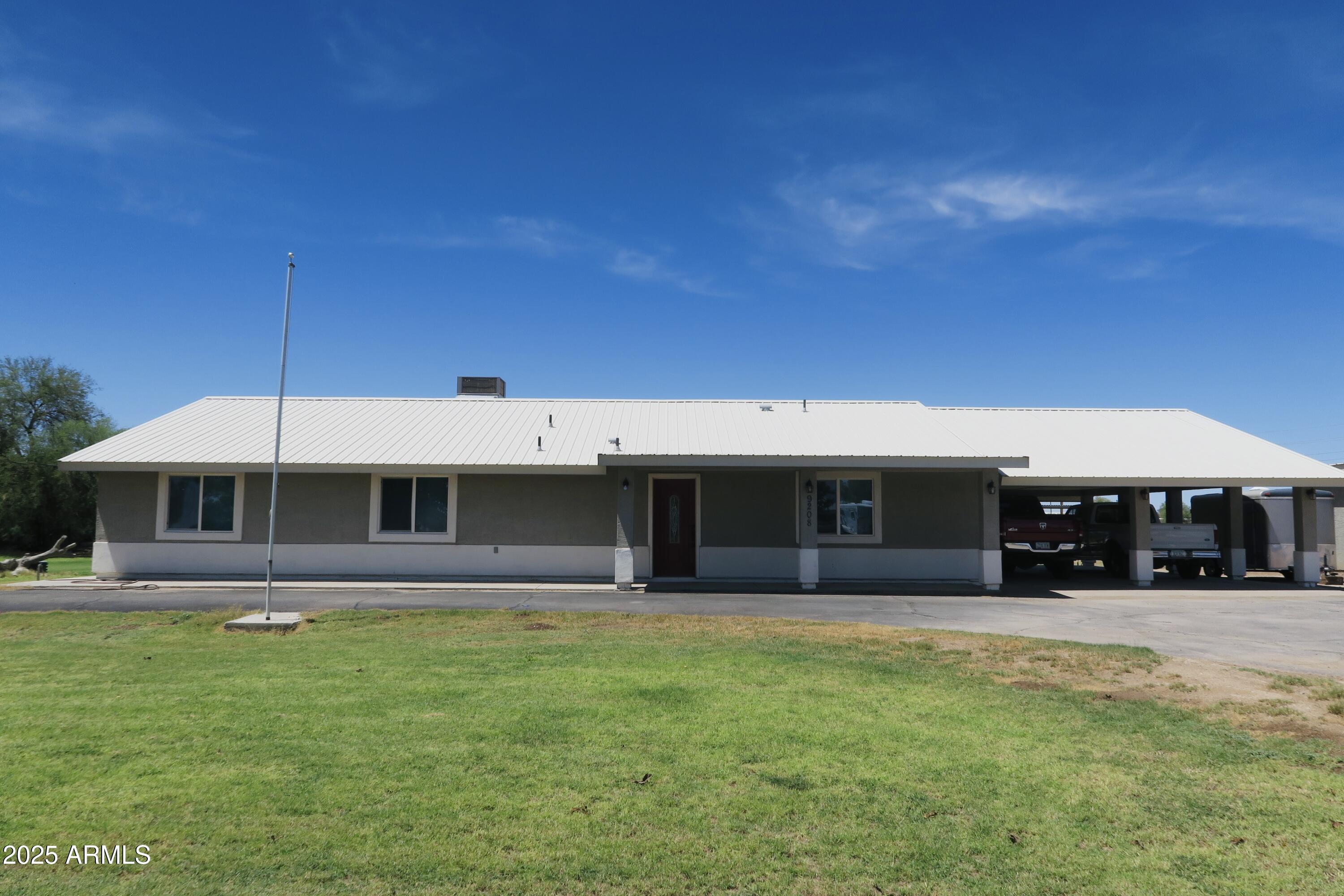 9208 South Palo Verde Road Buckeye, AZ 85326 - Photo 2 of 27 a front view of a house with a yard