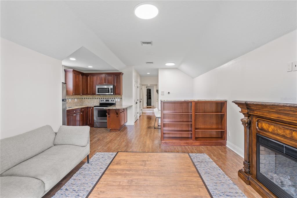 222 Acadia Terrace Celebration, FL 34747 - Photo 65 of 76 a living room with stainless steel appliances kitchen island granite countertop furniture and a fireplace