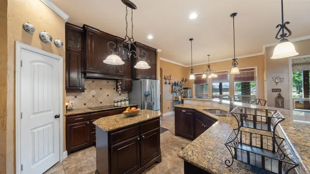 a kitchen with stainless steel appliances granite countertop a stove a sink and a refrigerator