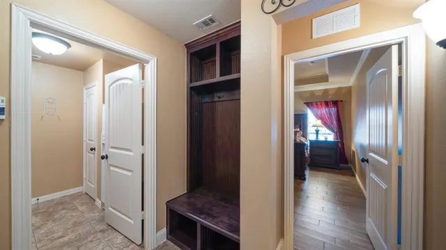 a view of a hallway with wooden floor and closet area