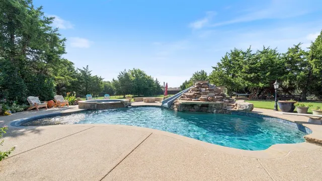 a view of a swimming pool with a patio and a yard