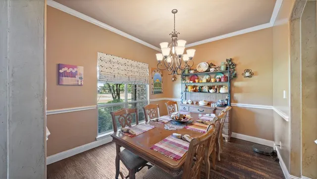 a view of a dining room with furniture wooden floor and chandelier