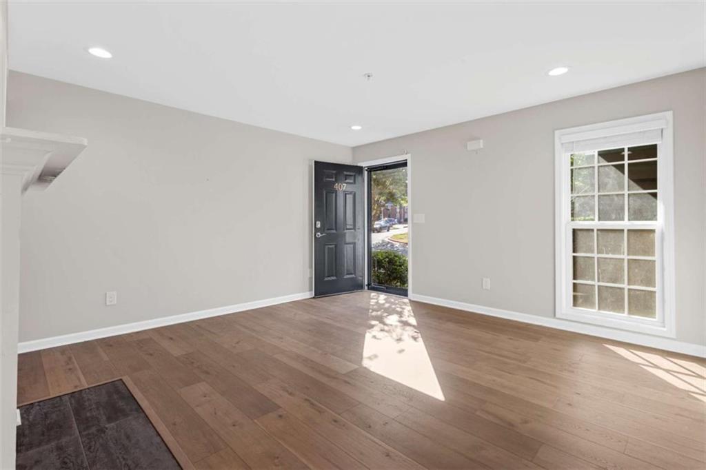 1166 Booth Road, Unit 407 Marietta, GA 30008 - Photo 2 of 18 an empty room with wooden floor and windows